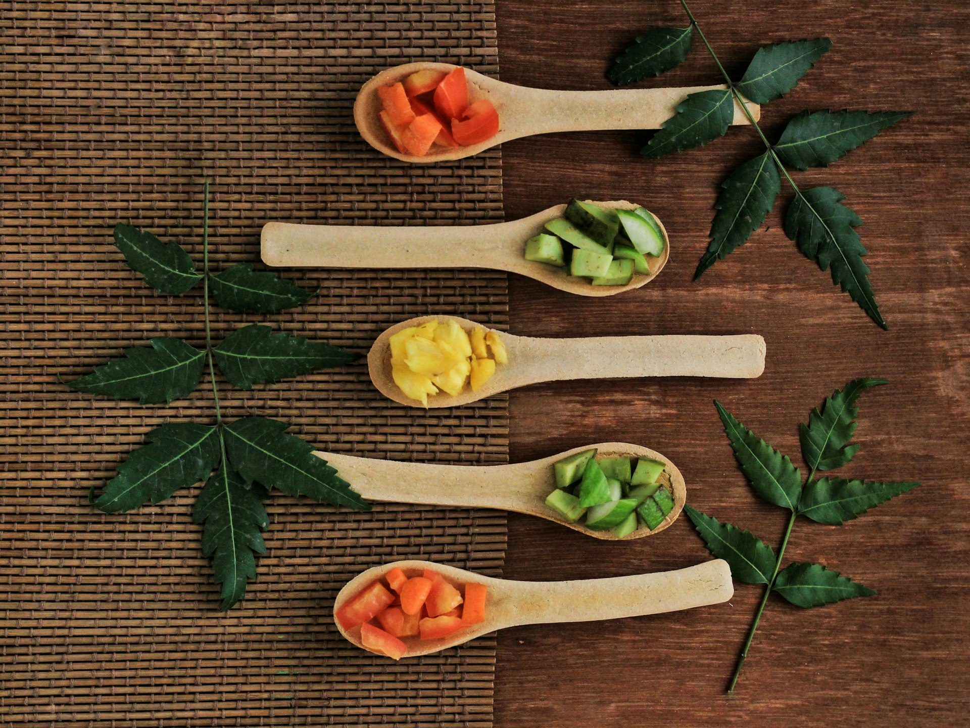 Five wooden spoons filled with different types of vegetables